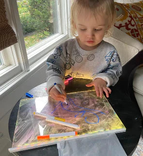Niño creando dibujos en la pizarra LumiBoard Neón